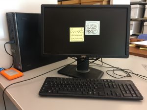 blank computer screen with two post-it notes on it indicating that the computer is ingesting. 