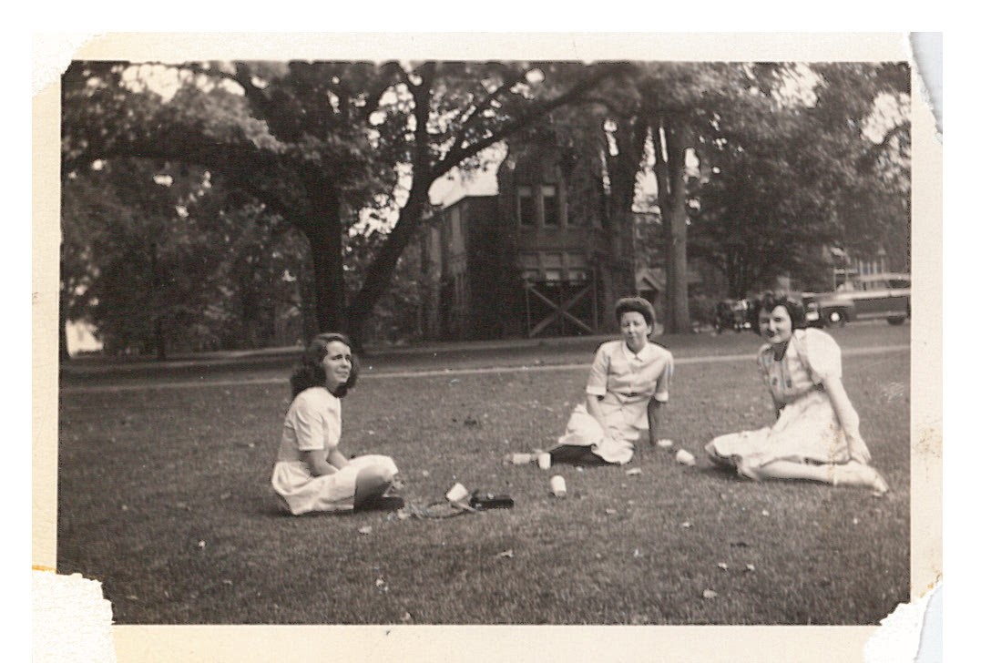 Three women sitting on the lawn.